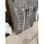A METAL WIRE FRAMED MANEQUIN ON A STAND