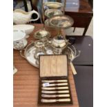 A LARGE ASSORTMENT OF SILVER PLATED ITEMS TO INCLUDE A TEA SERVICE, A CAKE STAND AND FLATWARE ETC