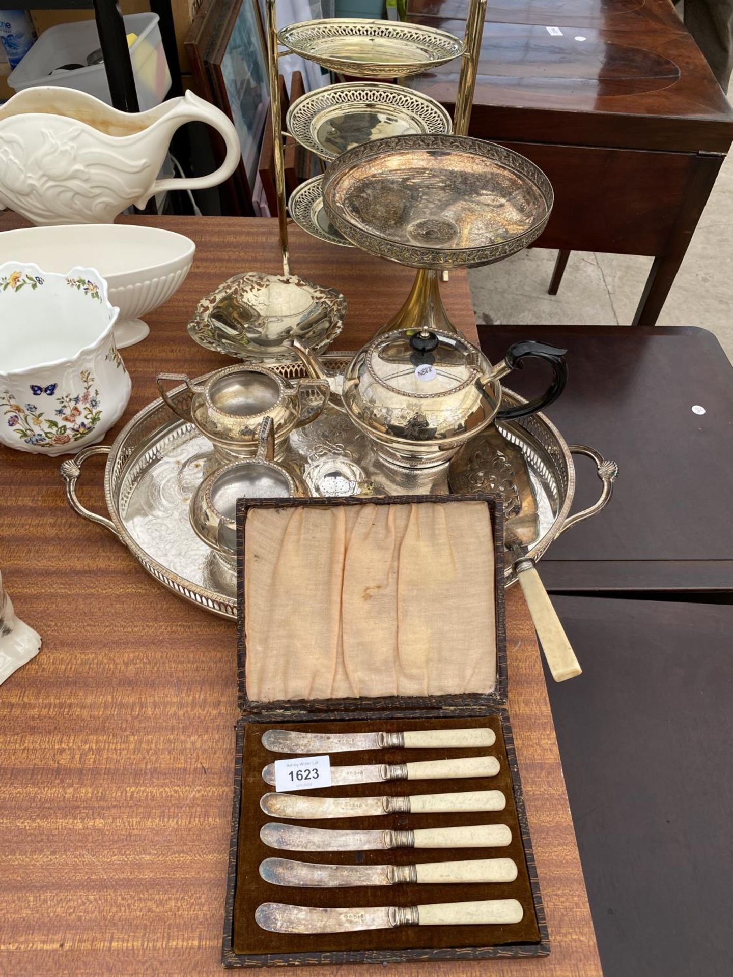 A LARGE ASSORTMENT OF SILVER PLATED ITEMS TO INCLUDE A TEA SERVICE, A CAKE STAND AND FLATWARE ETC