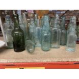 A LARGE QUANTITY OF VINTAGE GLASS BOTTLES WITH EMBOSSESD MAKERS NAMES, SOME WITH STOPPERS