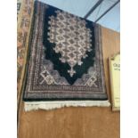 A BLACK PATTERNED FRINGED RUG