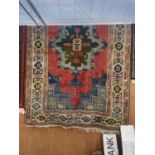 A LARGE COLOURFUL PATTERNED FRINGED RUG