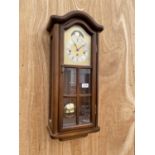 A WOODEN CASED VIENNA STYLE WALL CLOCK COMPLETE WITH PENDULUM AND KEY