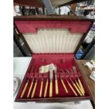 A CASED WOODEN CUTLERY BOX ALONG WITH A STERLING SILVER COLLARED KINFE AND FORK SET