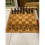 A WOODEN CHESS SET WITH FOLD AWAY BOARD - COMPLETE