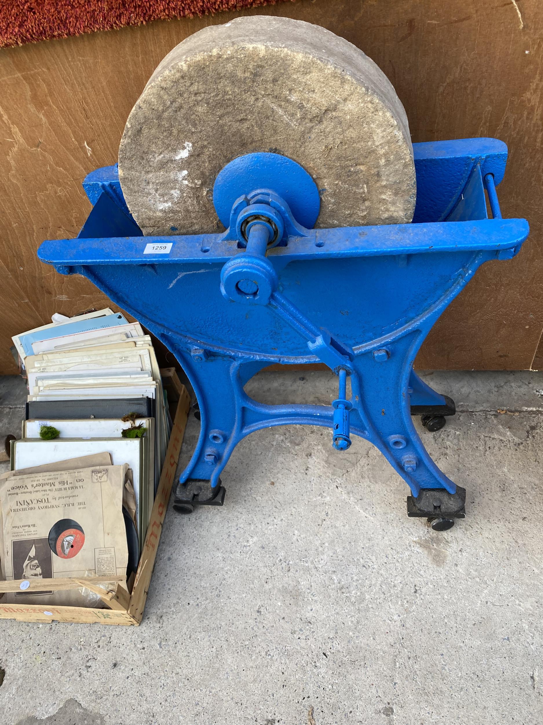 A VINTAGE SANDSTONE GRIND STONE WITH CAST IRON BASE