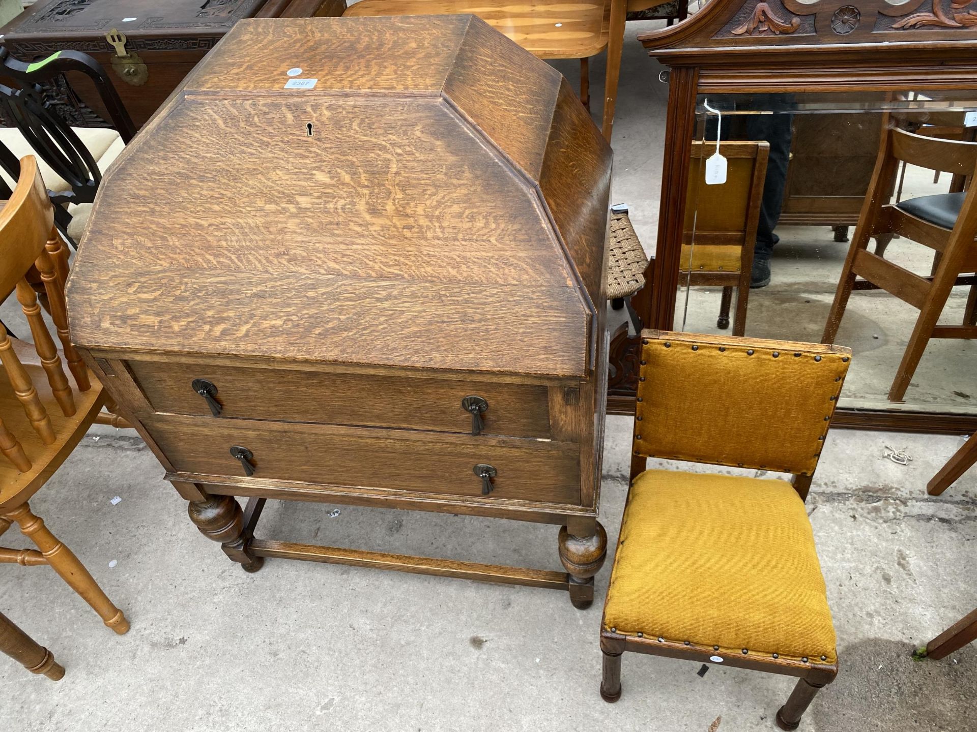 AN EARLY 20TH CENTURY OAK BUREAU WITH SARCOPHAGUS SHAPED TOP AND TWO DRAWERS, ON OPEN BASE, 29" WIDE