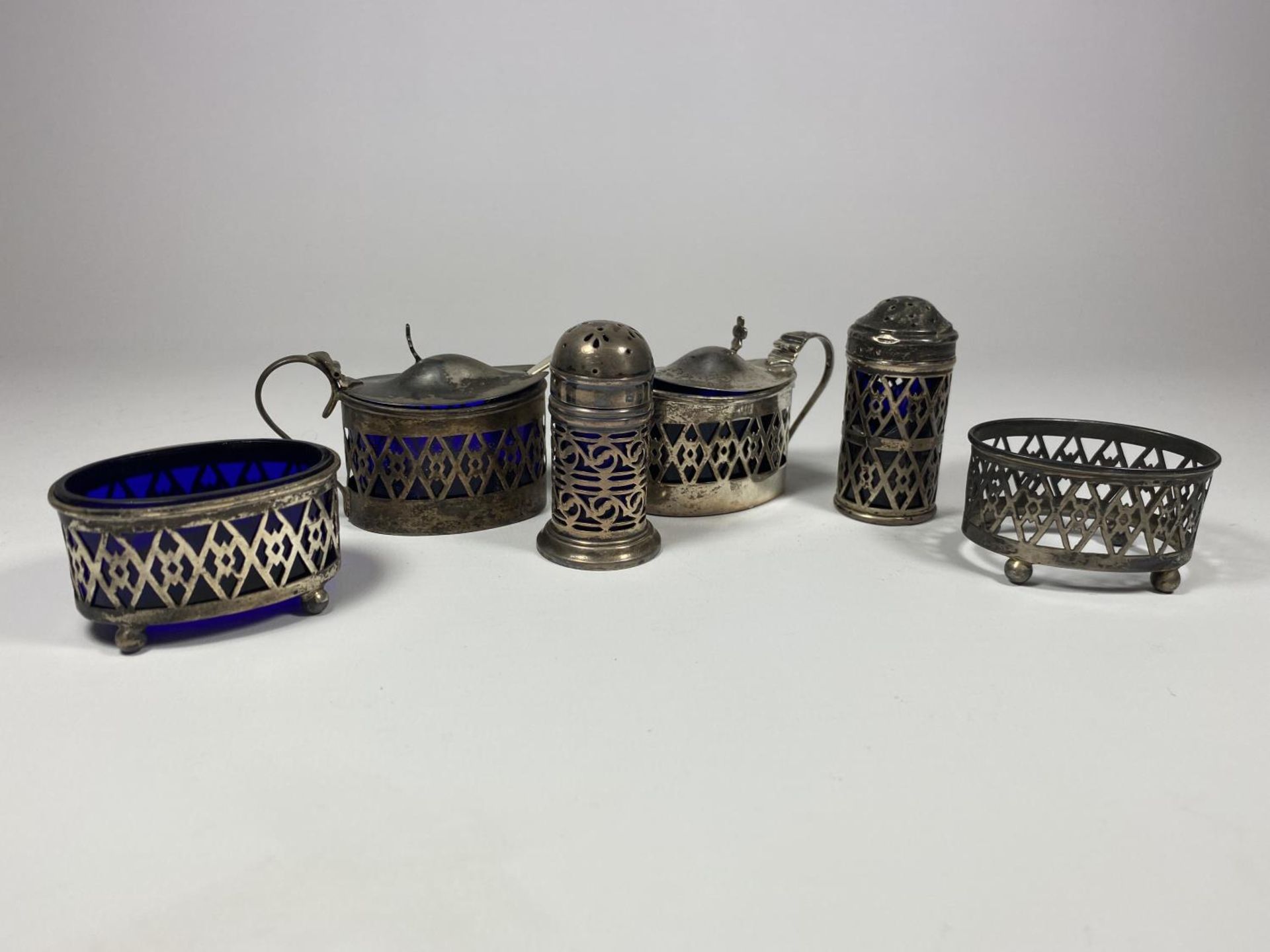 A HALLMARKED SILVER CONDIMENT SET COMPRISING MUSTARD POTS, OPEN SALT, SHAKERS AND FURTHER OPEN