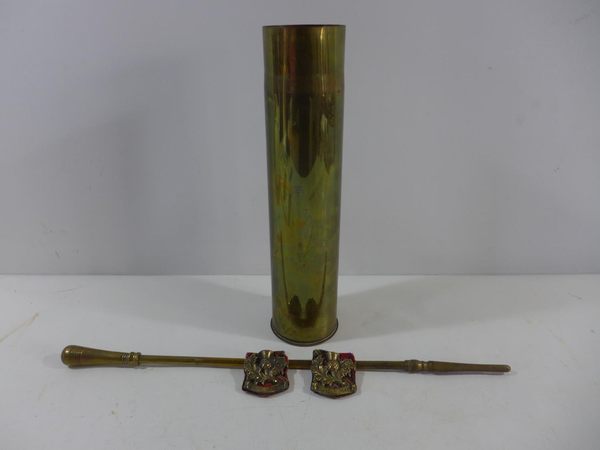 A BRASS SHELL CASE, HEIGHT 35CM, TWO CAST BRASS SCOTTISH BADGES AND A POKER (4)