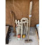 AN ASSORTMENT OF VINTAGE CROQUET ITEMS TO INCLUDE MALLETS, BALLS AND HOOPS ETC