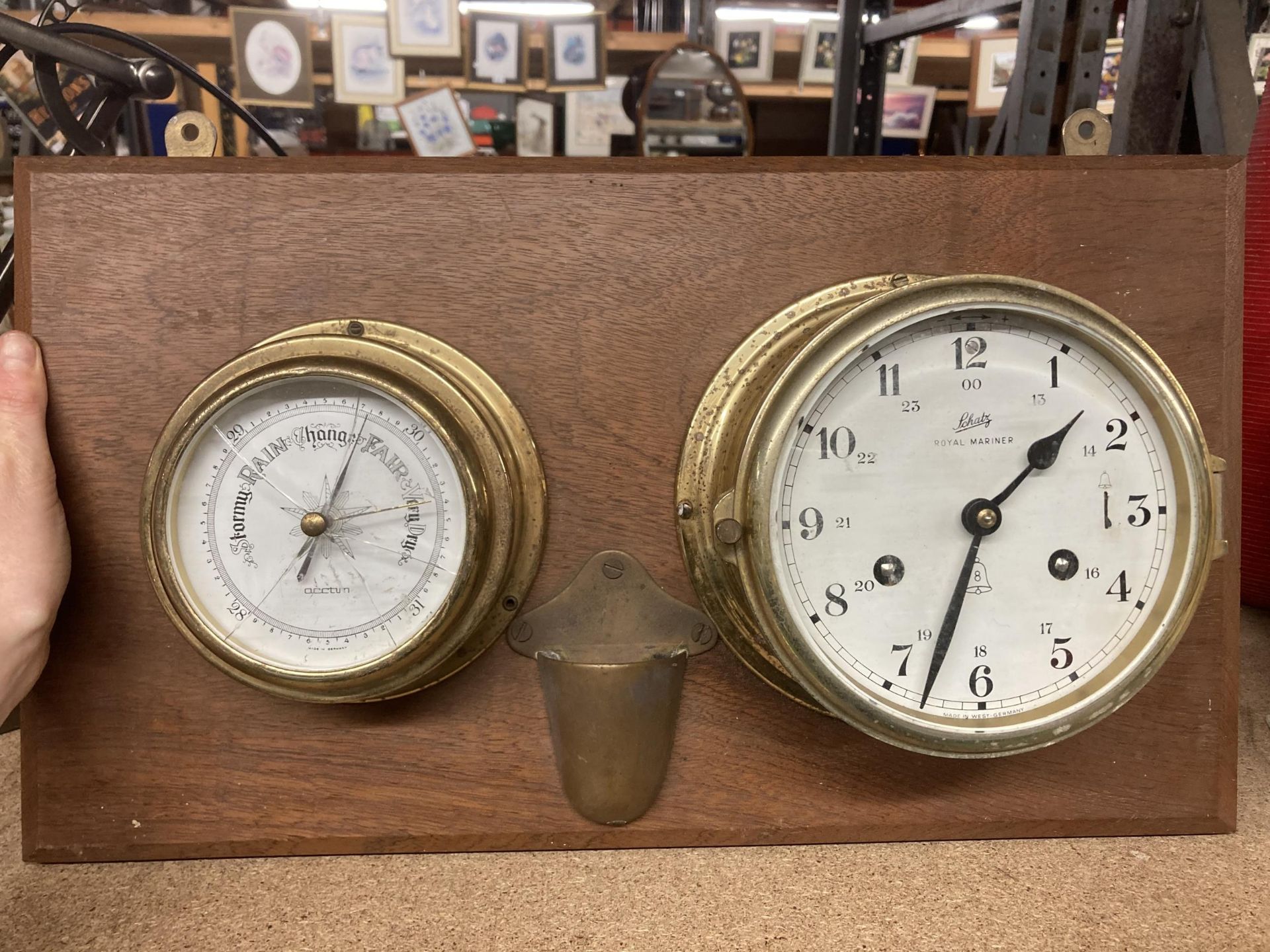 A BRASS BAROMETER AND CLOCK ON A WOODEN BASE