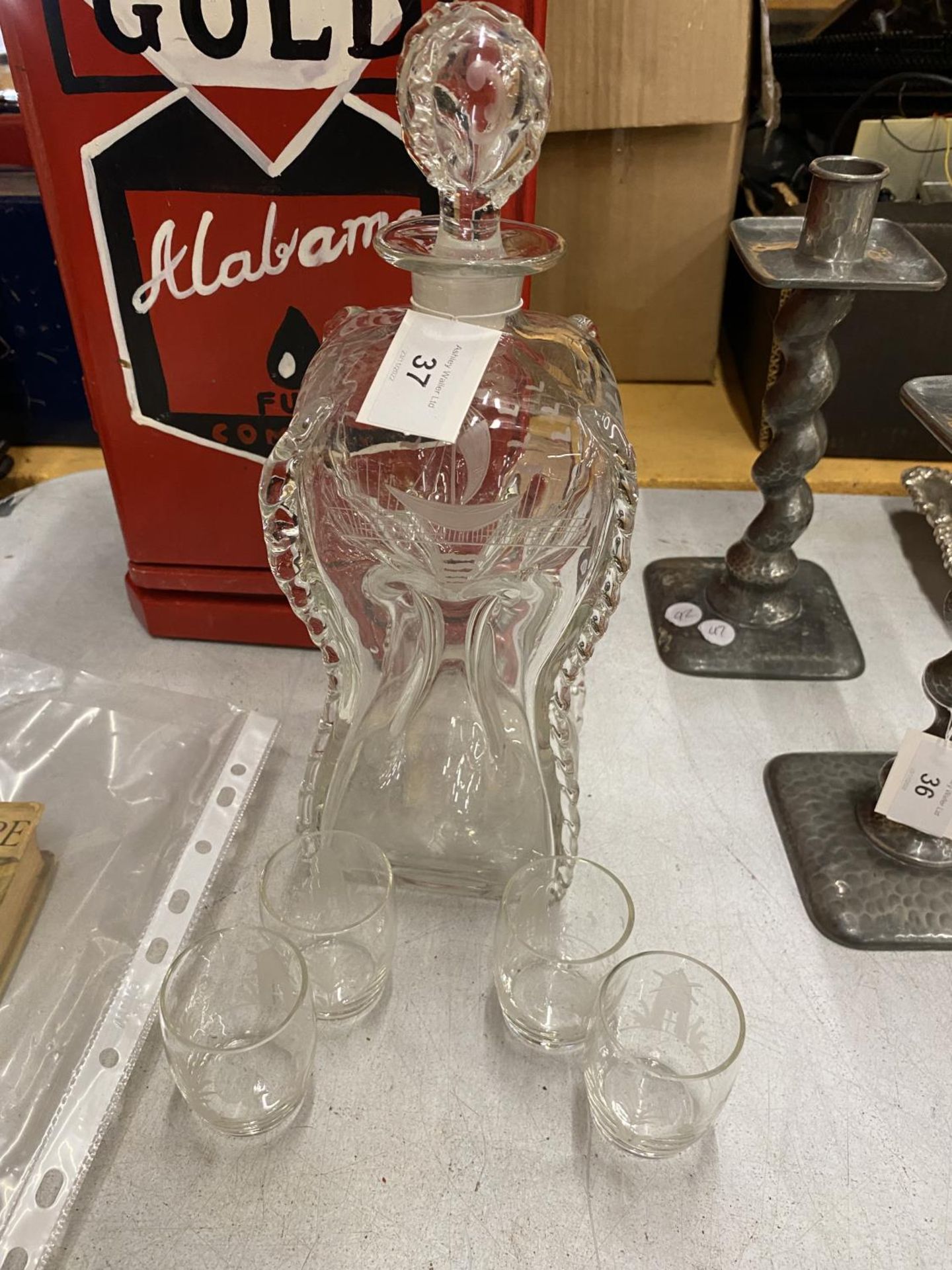 A VINTAGE GLASS DECANTER WITH WAISTED FORM DESIGN WITH FOUR SHOT GLASSES
