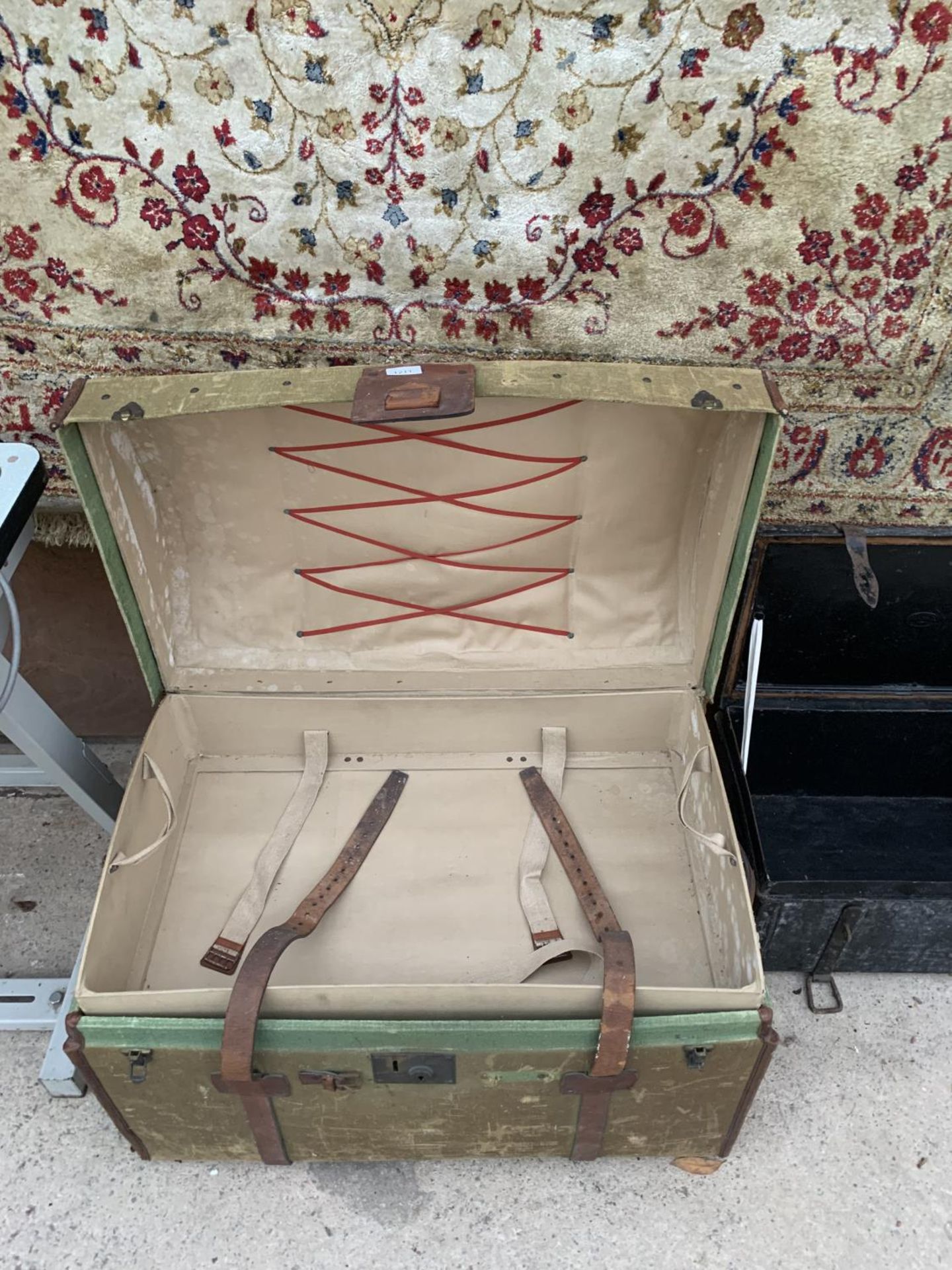 A VINTAGE DOME TOPPED TRAVEL TRUNK WITH LEATHER STRAPS AND CARRYING HANDLES