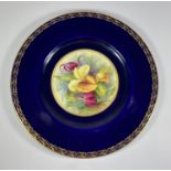 A ROYAL WORCESTER HAND PAINTED PORCELAIN PLATE, UNSIGNED, DEPECITING FLOWERS AGAINST A COBALT BLUE