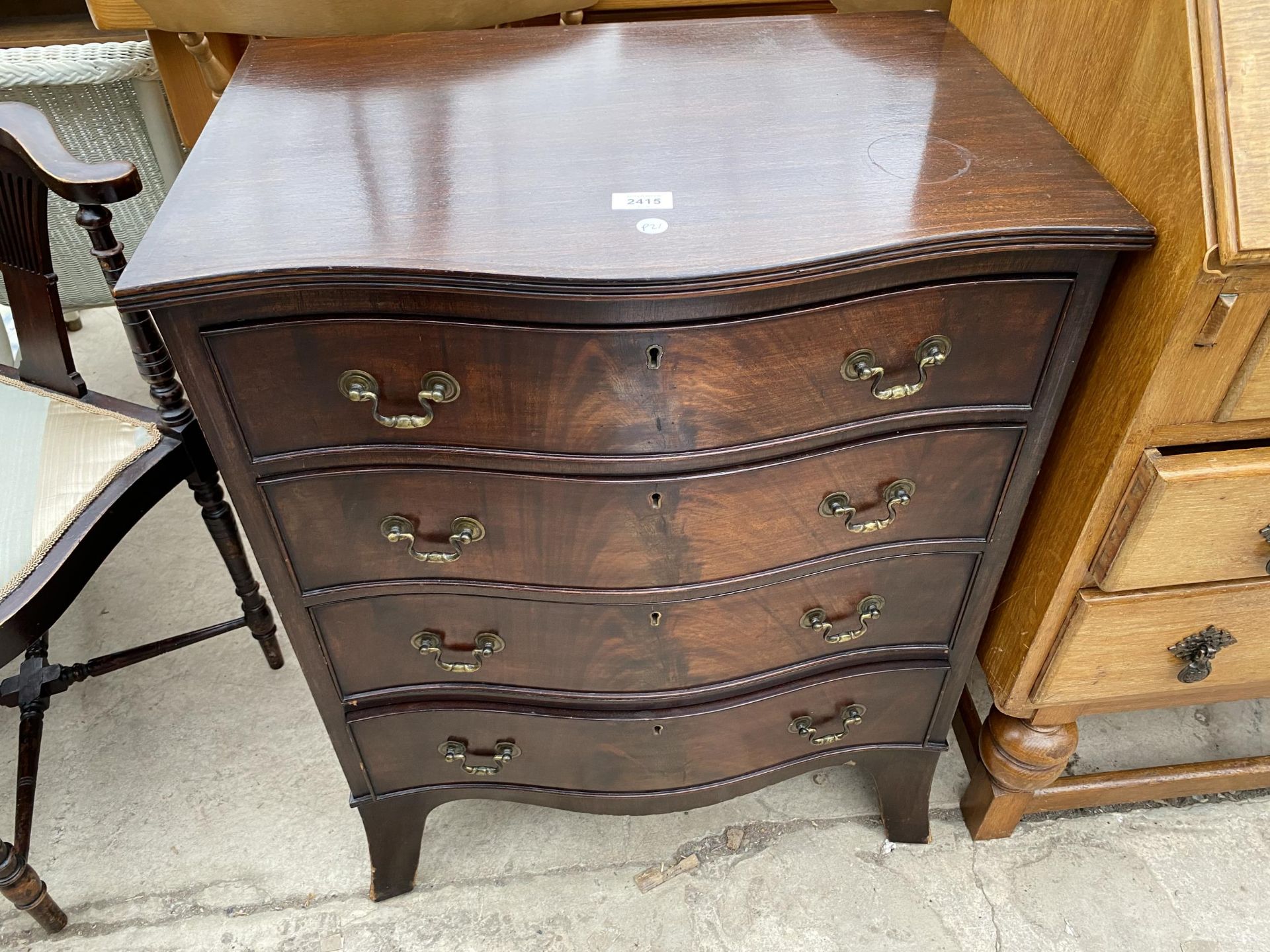 A REPRODUCTION MAHOGANY SERPENTINE FRONTED CHEST OF FOUR GRADUATED DRAWERS, 24" WIDE