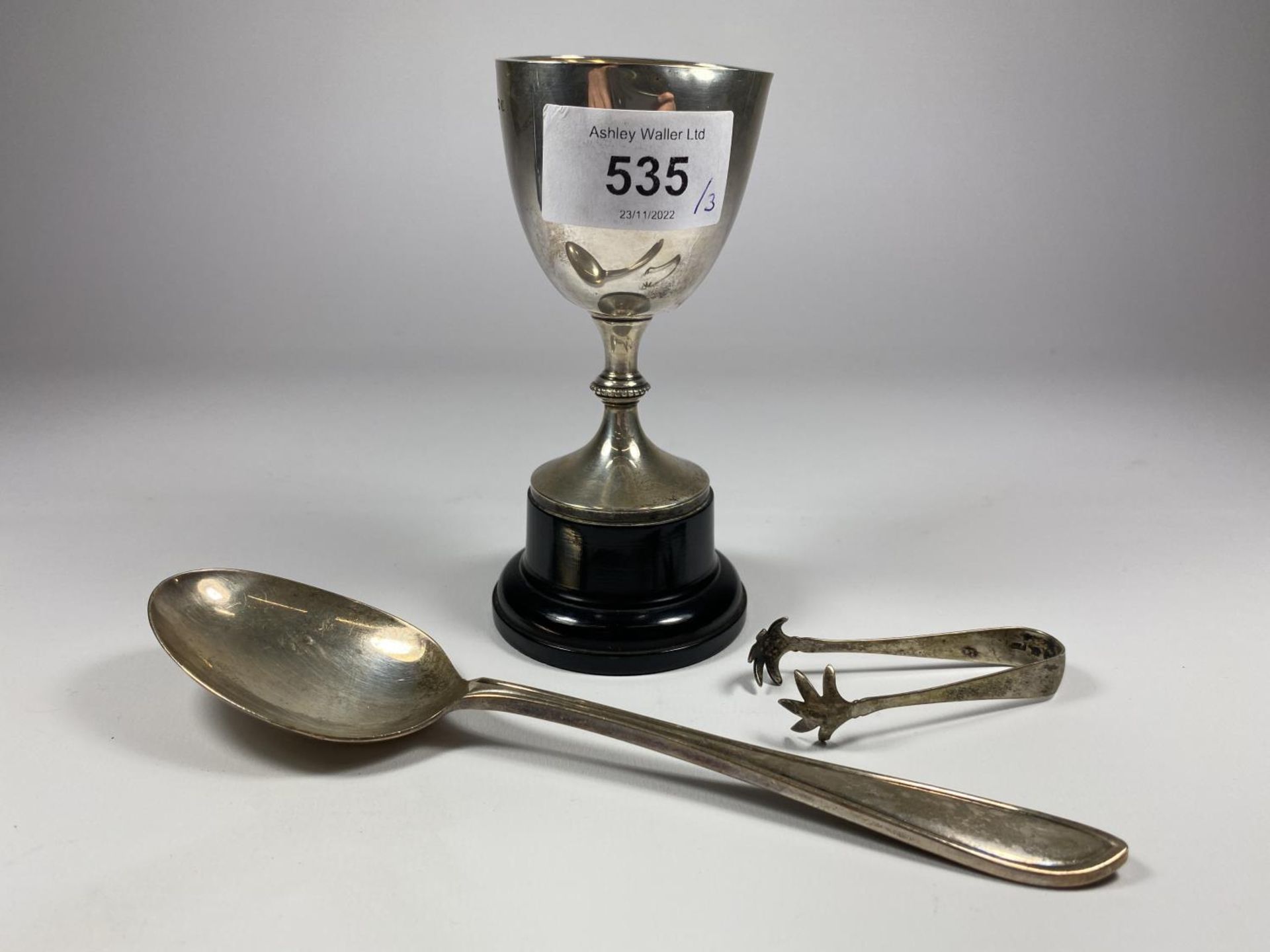 THREE HALLMARKED SILVER ITEMS - SMALL TROPHY ON BASE, TABLE SPOON AND SUGAR TONGS