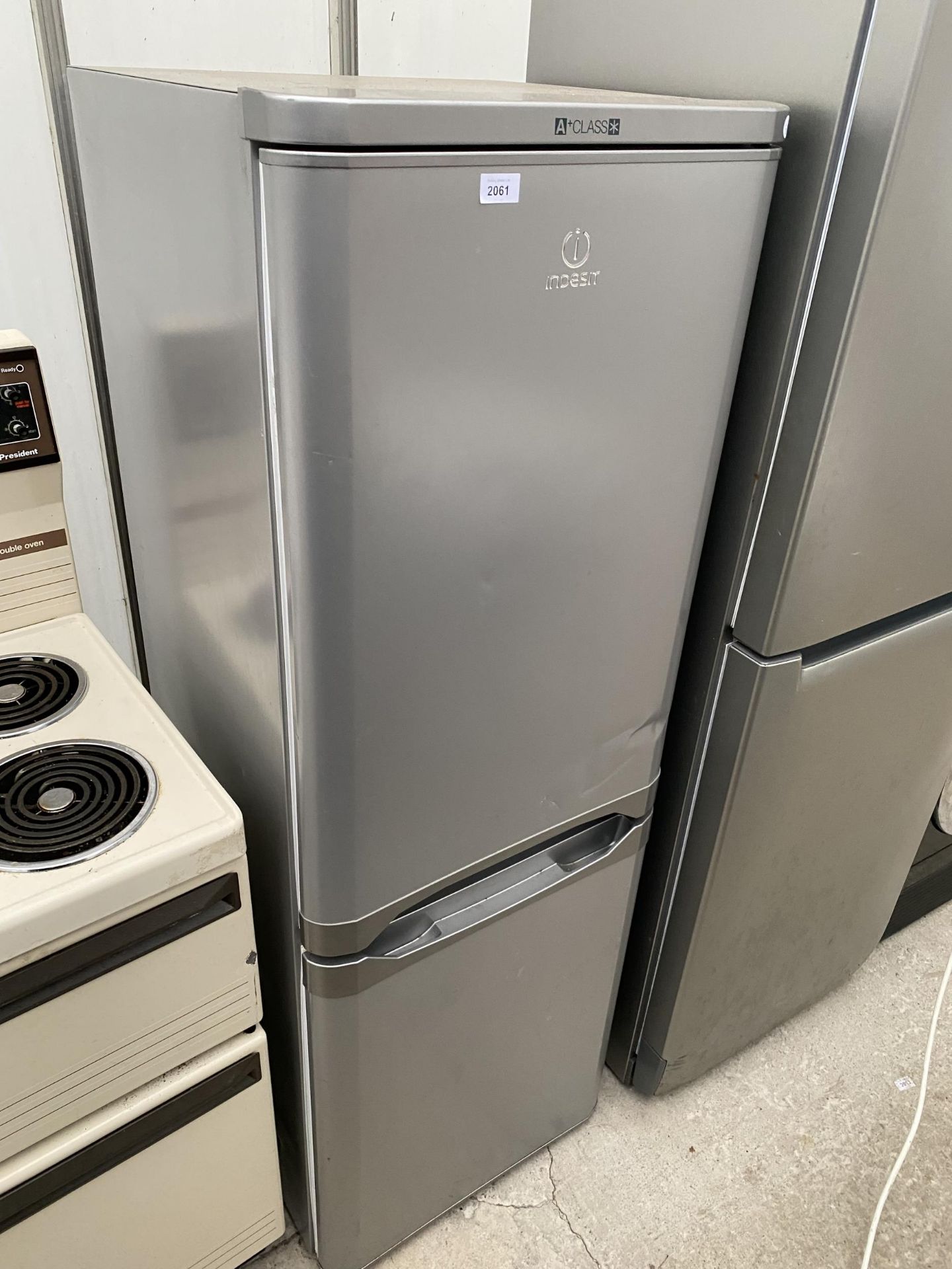 A SILVER INDESIT UPRIGHT FRIDGE FREEZER