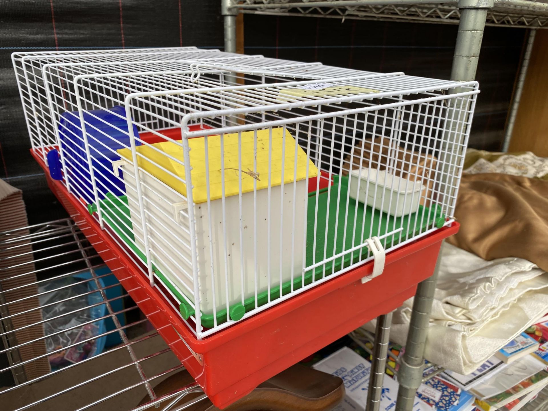 A HAMSTER CAGE WITH AN ASSORTMENT OF ACCESSORIES