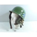 A GREEN PAINTED METAL HELMET AND LINER AND EAR PIECES