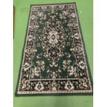 A GREEN PATTERNED WOOLLEN RUG 148CM X 80CM