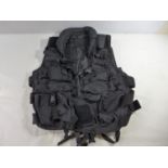 A BLACK TACTICAL LOAD BEARING VEST, WITH NUMEROUS POUCHES