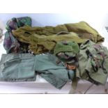 A WOOLEN THERMAL SLEEPING BAG, ASSORTED CAMOUFLAGE CLOTHING, WEBBING, GUN SLIPCASE ETC