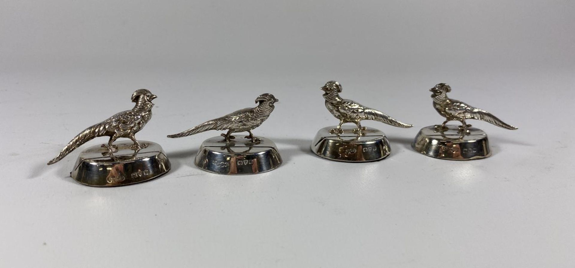 A SET OF FOUR GEORGE V HALLMARKED SILVER PHEASANT PLACEHOLDERS, DATES TO CHESTER, 1913