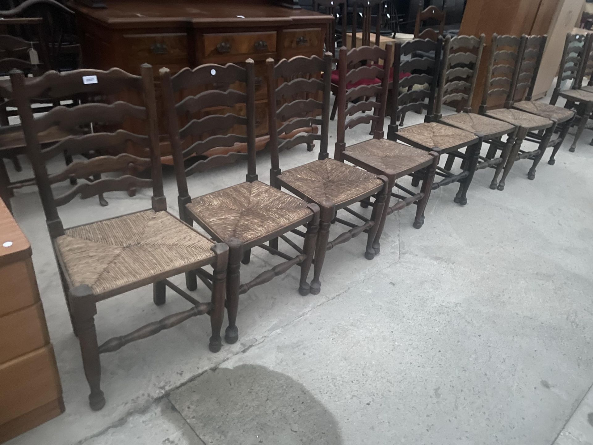 A SET OF EIGHT LANCASHIRE STYLE LADDERBACK DINING CHAIRS WITH RUSH SEATS