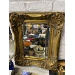 AN ORNATE RECTANGULAR GILT FRAMED MIRROR