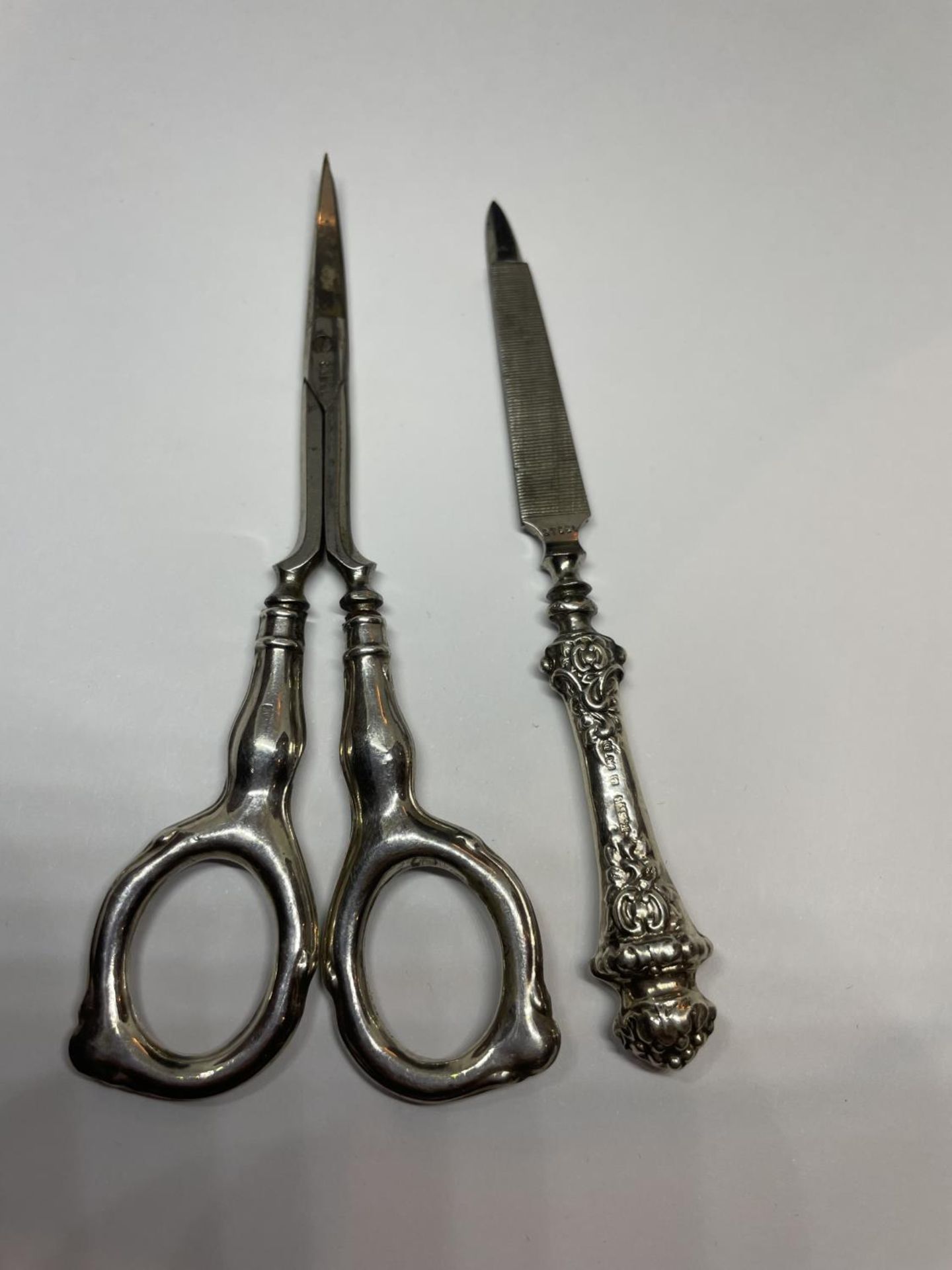 TWO SILVER HANDLED ITEMS TO INCLUDE A PAIR OF SISSORS AND A NAIL FILE - Image 2 of 3