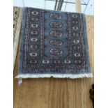 A SMALL BLUE PATTERNED FRINGED RUG