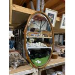 AN OVAL MIRROR IN WOODEN FRAME