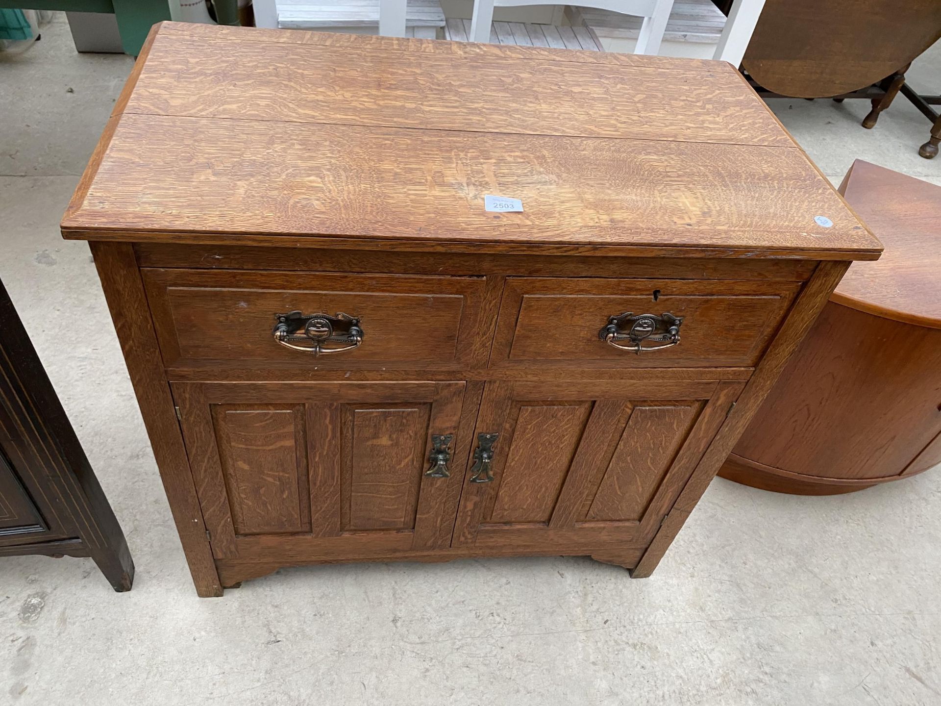 AN EDWARDIAN OAK SIDEBOARD ENCLOSING TWO PANELLED DOORS AND TWO FRIEZE DRAWERS, 32" WIDE