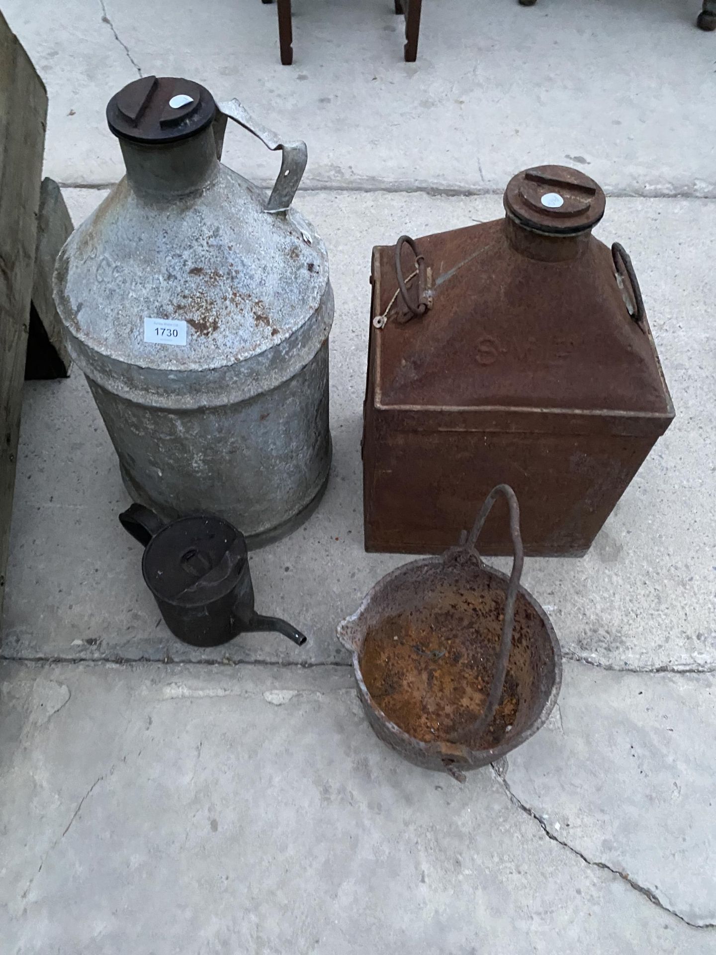 AN ASSORTMENT OF VINTAGE ITEMS TO INCLUDE TWO FUEL CANS, A CAST IRON COOKING POT AND AN OIL JUG