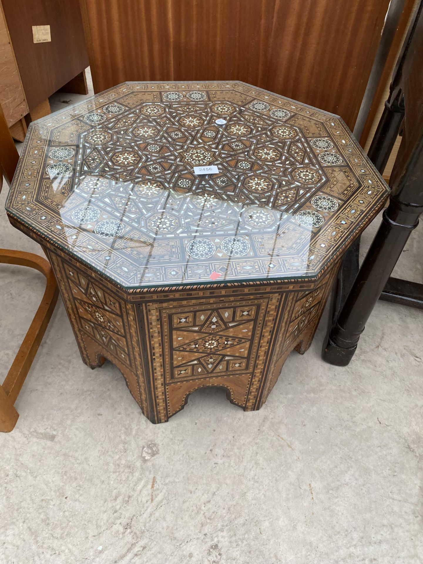 AN OCTAGONAL SYRIAN COFFEE TABLE PROFUSELY INLAID WITH MOTHER OF PEARL BEARING LABEL 'ABOUANI