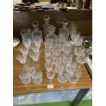 A LARGE QUANTITY OF GLASSWARE TO INCLUDE CUT GLASS DECANTERS, BRANDY GLASSES, WINE GLASSES,