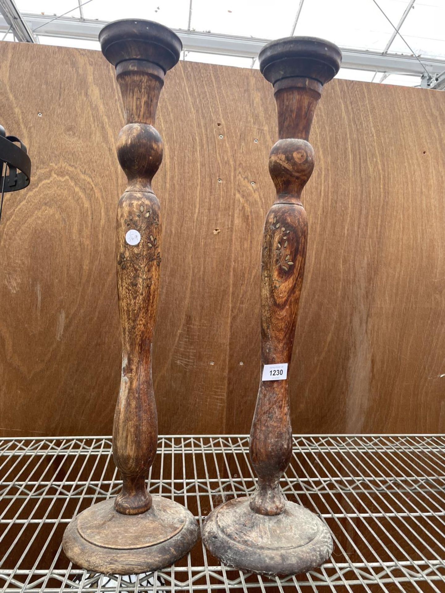 A PAIR OF CARVED WOODEN CANDLESTICKS WITH INSET FLORAL DESIGN