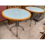 A PAIR OF 30" DIAMETER BISTRO TABLES WITH TWO TONE TOPS, ON CAST IRON BASES