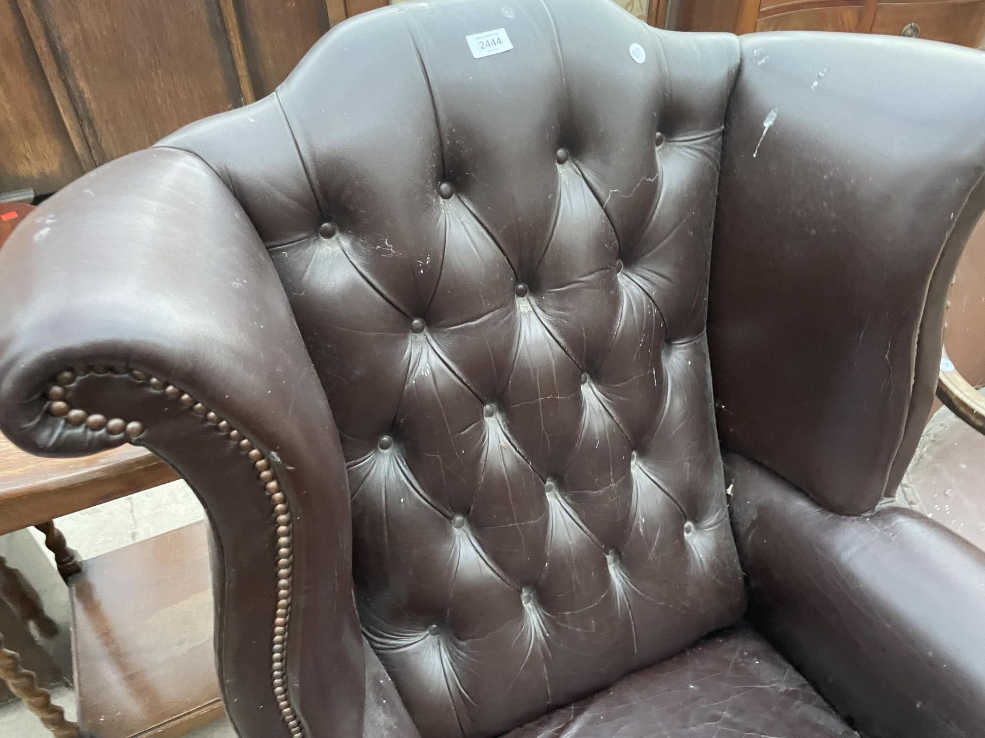 A BROWN FAUX LEATHER WINGED FIRESIDE CHAIR ON FRONT CABRIOLE LEGS, WITH BALL AND CLAW FEET - Image 2 of 4