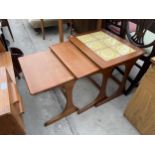 A RETRO TEAK NEST OF THREE TABLES, THE TOP TABLE BEING TILED