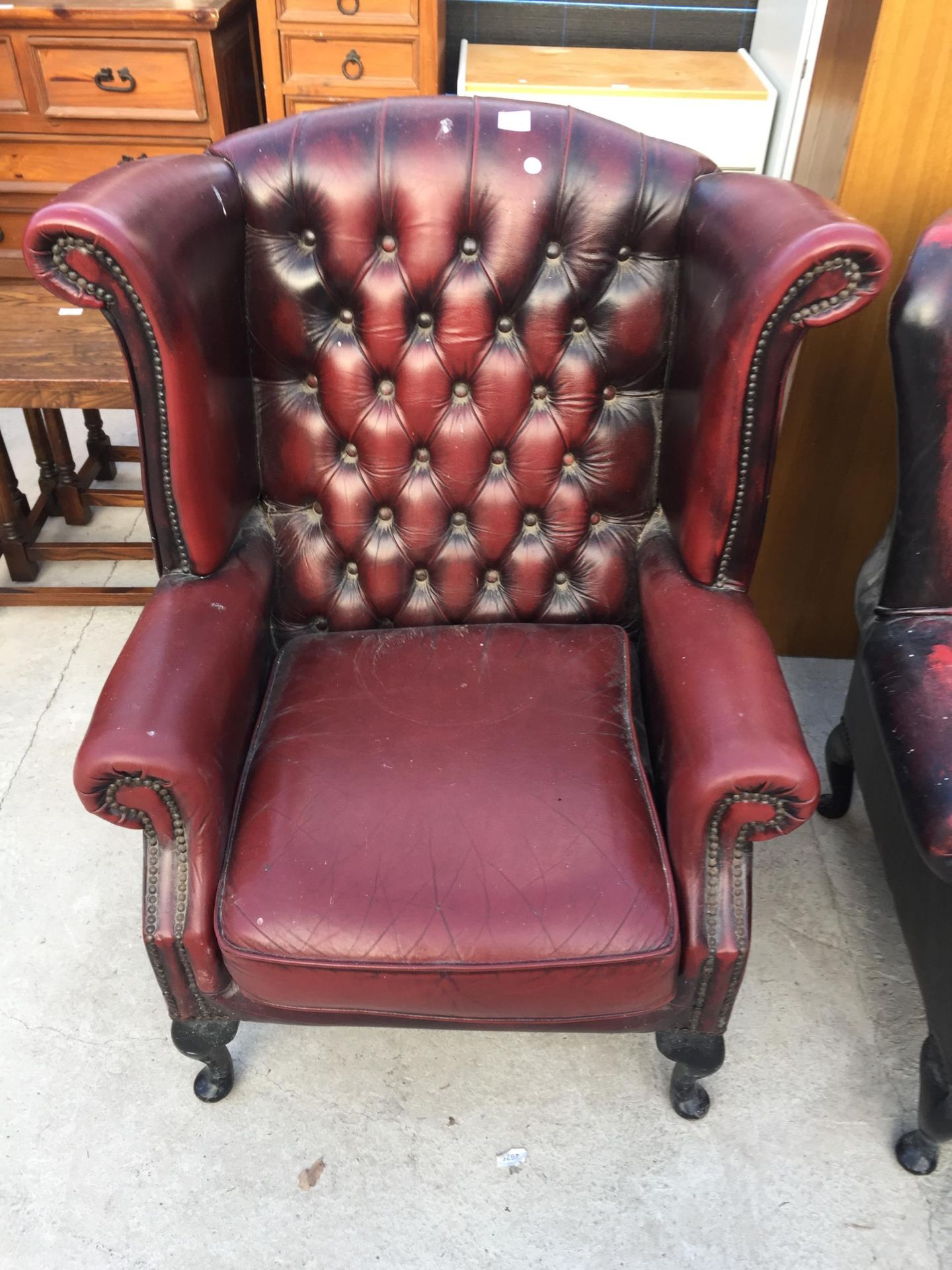 A THOMAS LLOYD OXBLOOD WINGED FIRESIDE CHAIR ON CABRIOLE LEGS