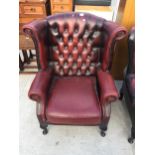 A THOMAS LLOYD OXBLOOD WINGED FIRESIDE CHAIR ON CABRIOLE LEGS