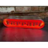 A FERRARI ILLUMINATED LIGHT BOX SIGN - WORKING ORDER AT TIME OF CATALOGUING. WIDTH 44CM, HEIGHT 10.