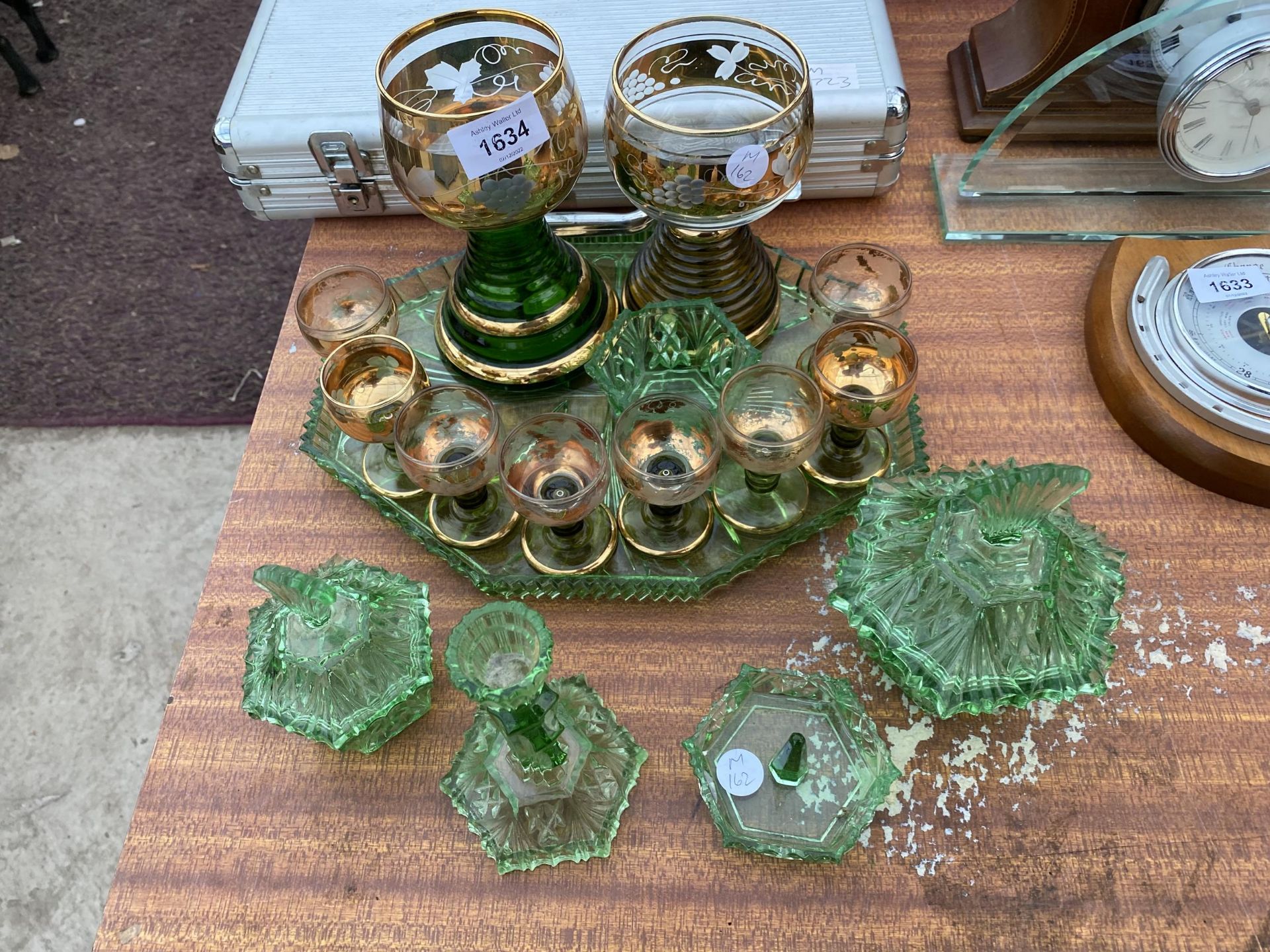 AN ASSORTMENT OF GREEN GLASS WARE TO INCLUDE SHERRY GLASSES AND A DRESSING TABLE SET ETC