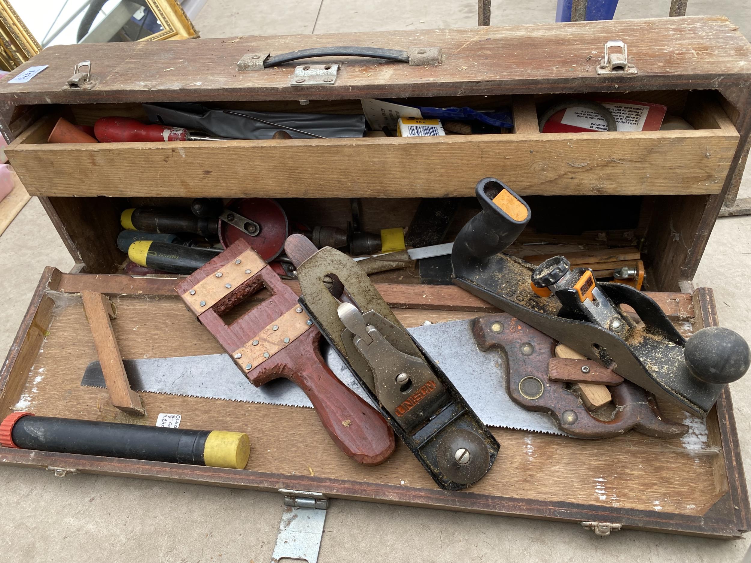 A VINTAGE WOODEN JOINERS CHEST COMPLETE WITH TOOLS TO INCLUDE A SAW AND TWO WOOD PLANES ETC