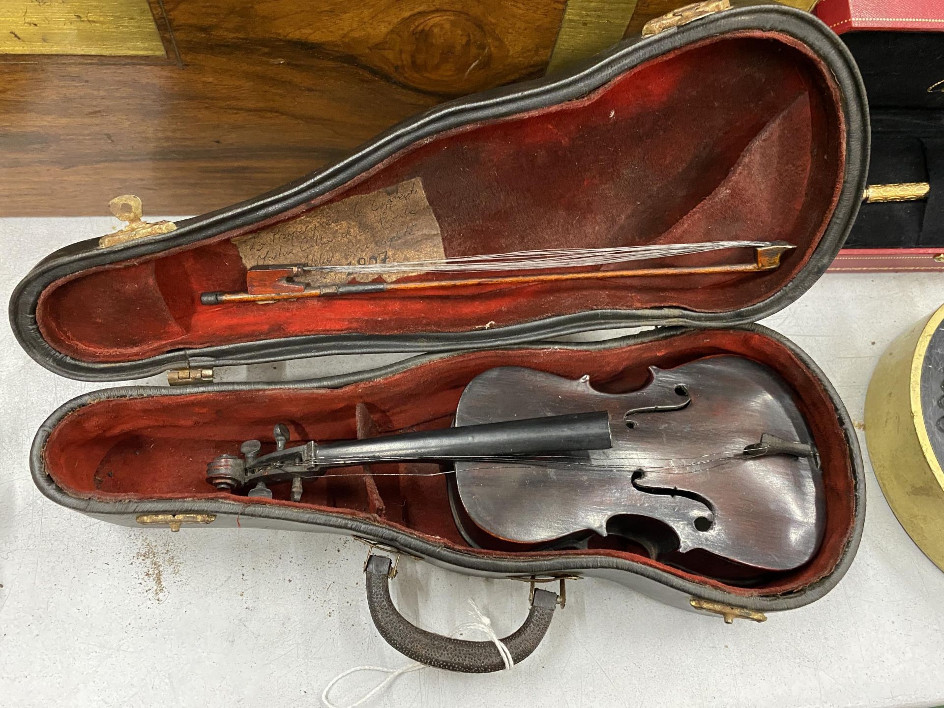 AN EARLY 20TH CENTURY MINIATURE CASED VIOLIN AND BOW, LENGTH 23CM, CASE A/F