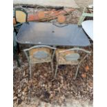 A GLASS TOPPED METAL GARDEN TABLE AND FOUR CHAIRS