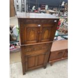 A PRIORY STYLE OAK CABINET WITH TWO UPPER AND ONE LOWER DOOR AND TWO CENTRE DRAWERS