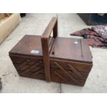 A VINTAGE WOODEN CONCERTINA SEWING BOX WITH AN ASSORTMENT OF SEWING ITEMS TO INCLUDE THREAD ETC