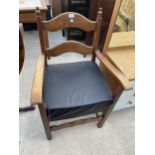 A BEECH FRAMED ELBOW CHAIR WITH FAUX BLACK LEATHER SEAT
